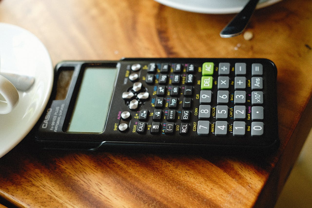 Detailed view of a scientific calculator placed on a wooden table surface.